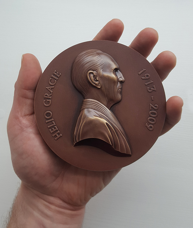Jiu Jitsu art - Jody Clark (artist) holding bronze medal with Helio Gracie on it